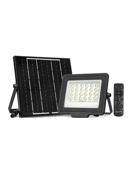 proyector solar LED 1200 lm iluminando jardín de noche