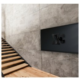 “soporte TV de pared giratorio e inclinable Holmios instalado en salón moderno”